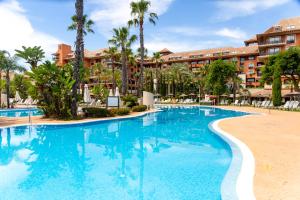 a swimming pool in front of a resort at Puerto Antilla Grand Hotel in Islantilla