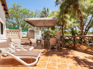 patio con tavolo, sedie e ombrellone di Spectacular holiday home in Santa Cruz de Tenerife with private pool ad Atogo