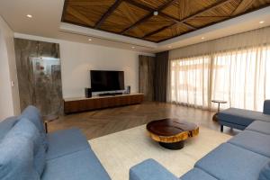 Sala de estar con 2 sofás azules y mesa de centro en Bab Al Nojoum Bateen Liwa, en Liwa