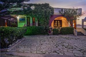 a house with a stone driveway in front of it at Villa Georgia Apartments & Suites in Kalamaki