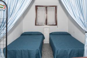 クリェラにあるProvence, 7º-25の青いシーツと窓が備わる客室で、ベッド2台が備わります。