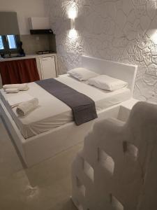 a bedroom with a white bed with towels on it at Traditional house under the castle in Astypalaia Town