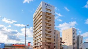 a tall building with a sign on the side of it at Toyoko Inn Osaka Bentencho in Osaka