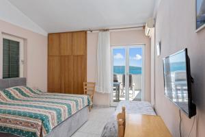 a bedroom with a bed and a view of the ocean at Aparthotel Vila Danica in Dobropoljana