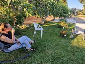 a woman sitting in a lawn chair in the grass at Meraviglia d'Otranto in Otranto