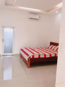 1 dormitorio con 1 cama en una habitación blanca en Hotel Như Ý Hồ Tràm, en Thuận Biên