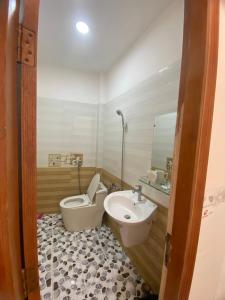 y baño con aseo y lavamanos. en Hotel Như Ý Hồ Tràm, en Thuận Biên