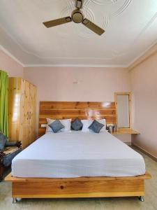 a bedroom with a large bed with a ceiling fan at Shakoon Camps & Farmstay Nainital in Nainital