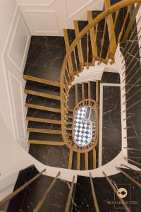 a spiral staircase in a house with black marble at Castelar Palace & SPA by Seaward Suites in Villajoyosa