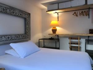a bedroom with a white bed and a lamp at Casa Mamma Bruna in San Vito lo Capo