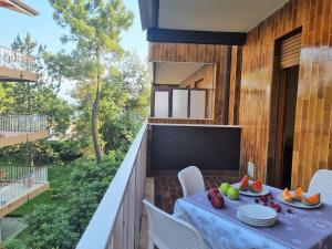 einen Balkon mit einem Tisch und Stühlen sowie einem TV in der Unterkunft Appartamenti Aurora in Grado