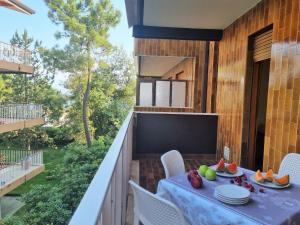 a balcony with a table and chairs and a television at Appartamenti Aurora in Grado