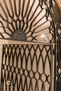 Una puerta de hierro con un reloj encima. en Castelar Palace & SPA by Seaward Suites, en Villajoyosa
