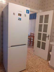 białą lodówkę w kuchni obok drzwi w obiekcie Casa de Campo en Playa Dosel 2 w mieście Mareny de San Lorenzo