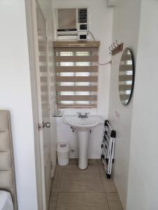 a white bathroom with a sink and a mirror at Grand Blue Beach Hotel in Boracay
