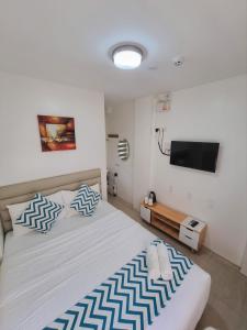 1 dormitorio con 1 cama grande con almohadas azules y blancas en Grand Blue Beach Hotel en Boracay