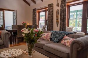 a living room with a couch and a table with flowers at Serenity House Pemberton & Wellness Spa in Pemberton +69 photos