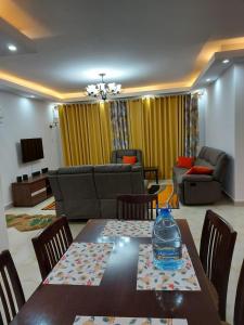 een woonkamer met een tafel en een bank bij the perfect affordable apartments in Nairobi