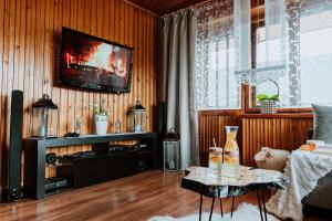 een woonkamer met een televisie en een tafel met drankjes erop. bij Tatra House in Poronin