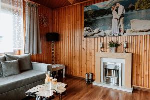 a living room with a couch and a fireplace at Tatra House z Jacuzzi in Poronin