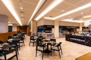 a restaurant with tables and chairs and a buffet at Puerto Antilla Grand Hotel in Islantilla