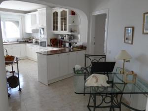 a kitchen with a glass table with a laptop on it at Viva La Vida ! - Cristall Beach Villa in Miami Platja