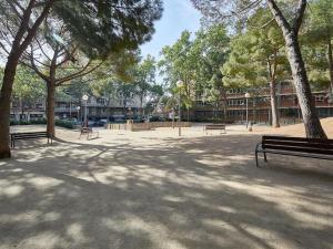 park z ławkami, drzewami i budynkami w obiekcie Bed&BCN Arquimedes Barcelona w Barcelonie