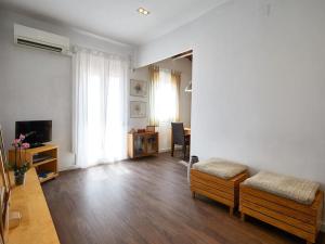 a living room with wooden floors and a living room with a tv at Bed&BCN Arquimedes Barcelona in Barcelona