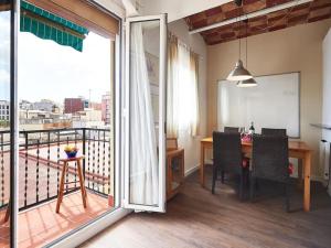 a dining room with a table and a balcony at Bed&BCN Arquimedes Barcelona in Barcelona