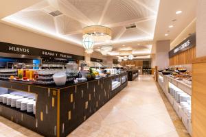 a restaurant with a buffet line with food at Puerto Antilla Grand Hotel in Islantilla