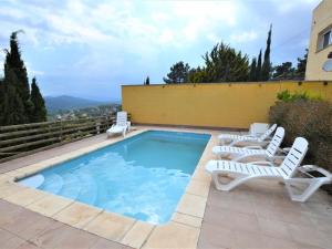 una piscina con 2 sillas y una piscina en Villa Alzina9 pax Lloret de mar, en Vidreres