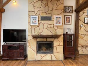 a living room with a stone wall with a fireplace at Apartmány Laverna in Ružomberok