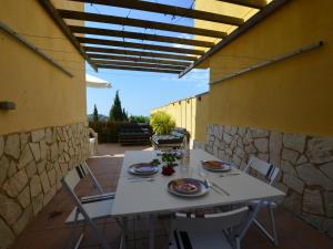 una mesa blanca y sillas en un patio en Villa Alzina9 pax Lloret de mar, en Vidreres