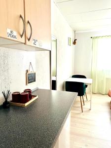 a kitchen with a black counter top and a table at 5 minute walk to LEGO house - n3 in Billund