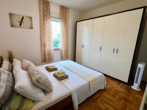 una camera da letto con un letto e due asciugamani di Sunny apartment by the beach a Kaštel Štafilić