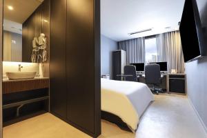 a hotel room with a bed and a bathroom at Wonju Brown Dot Hotel Corporate Business in Wonju