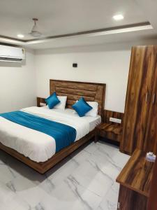 sypialnia z dużym łóżkiem z niebieskimi poduszkami w obiekcie Hotel Ozone,Ahmedabad w mieście Ahmadabad
