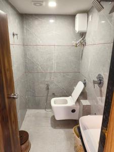 Hotel Ozone,Ahmedabad في أحمد آباد: حمام صغير مع مرحاض ومغسلة