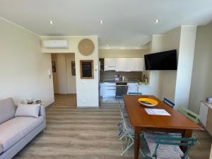a living room and kitchen with a table and a couch at Caprice 2.0 in Peschiera del Garda