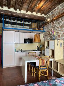 a kitchen with white cabinets and a table with a chair at La Conchiglia in Scarlino