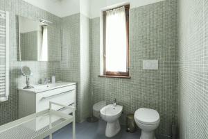 a bathroom with a toilet and a sink and a mirror at il larice d' oro in Sueglio +14 photos