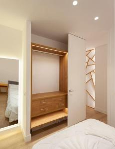 ein Schlafzimmer mit einem Schrank mit einem Bett und einem Spiegel in der Unterkunft Luxury flat Chamberi II in Madrid