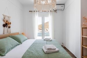 1 dormitorio con 1 cama con toallas en My Kythnos House, en Kithnos
