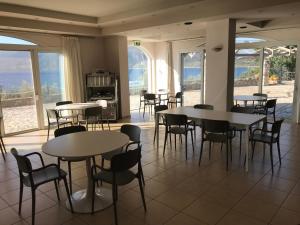 ein Esszimmer mit Tischen, Stühlen und Fenstern in der Unterkunft Annema Hotel and Restaurant in Monemvasia