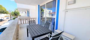 - Balcón con mesa y sillas en un edificio en Apartamentos Can Marsalet en Puerto Colom