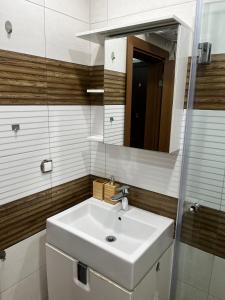 Un baño con un lavabo blanco y un espejo. en Niko's deluxe apartment, en Sofía