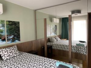 a bedroom with two beds and a mirror at Niko's deluxe apartment in Sofia