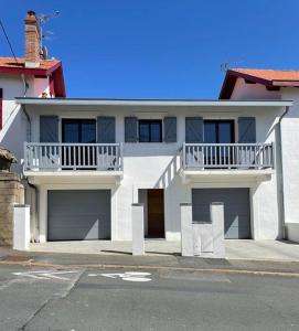 une maison blanche avec un balcon et 2 garages dans l'établissement Bord de Mer - Adorable maison au calme - 6 pers., à Biarritz