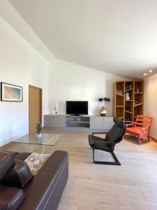 - un salon avec un canapé en cuir et une télévision dans l'établissement Bord de Mer - Adorable maison au calme - 6 pers., à Biarritz