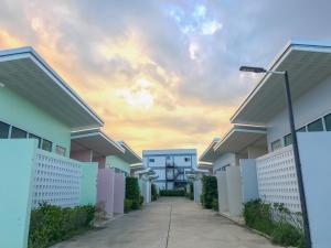 a row of houses with a cloudy sky in the background at โรงแรมสบาย พาเลซ in Nakhon Si Thammarat